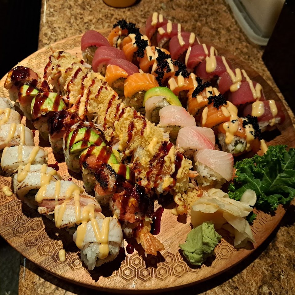 Sushi rolls arranged on a dark plate.